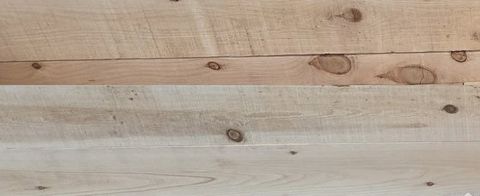 Close-up of cedar boards with dark knots and saw marks