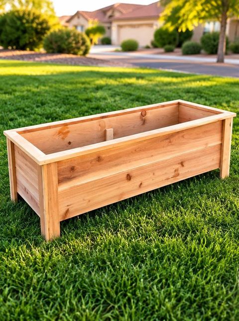 A rectangle cedar planter with corner legs sitting on a green lawn in low sun
